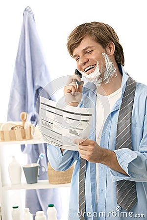 Man reviewing document while shaving Stock Photo