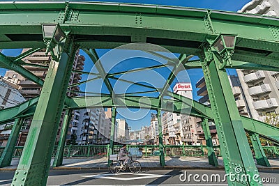 Man riding a bicycle at Yanagi Bridge (Yanagibashi) over Kanda River (Kandagawa). Asakusa Bridge (Asakusabashi) in the background Editorial Stock Photo