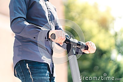 Man riding electric scooter in city. Businessman driving e kick vehicle in street. Stock Photo