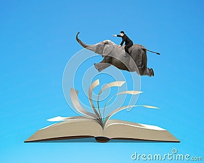 Man riding elephant flying on top flipping pages of open book is Stock Photo