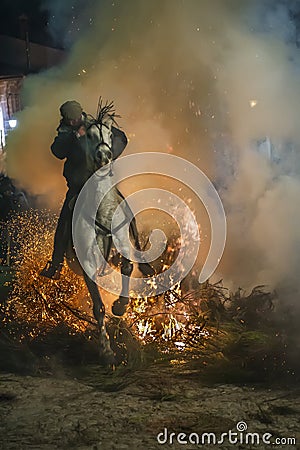 A man riding his horse jumping throug the fire Editorial Stock Photo
