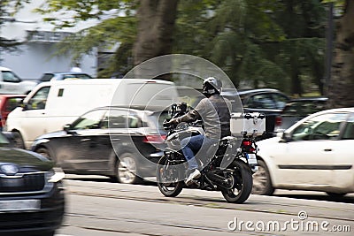 Man riding a motorbike on busy city street traffic Editorial Stock Photo