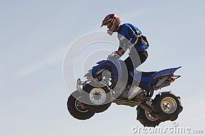 Man Riding Quad Bike In Midair Against Sky Stock Photo