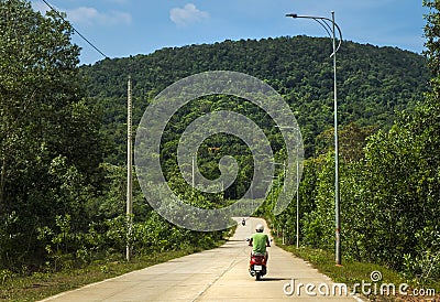 Man riding red scooter down the beautiful road Stock Photo