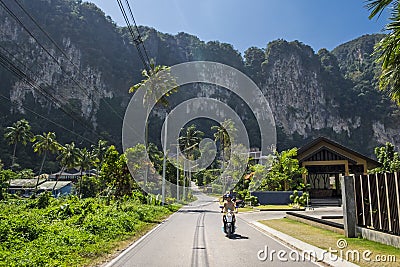 A man riding a scooter on the beautiful road in Krabi province, Thailand Stock Photo