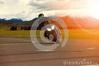 man riding sport motorcycle leaning in sharp curve with traveling scene background Stock Photo