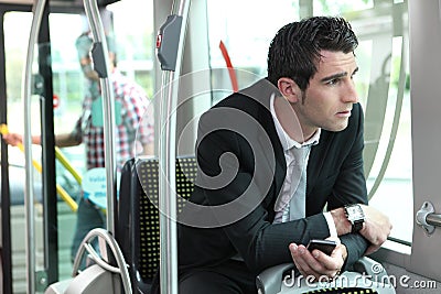 Man riding tram to work Stock Photo