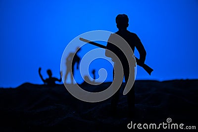 Man with riffle against zombie attack. Zombie apocalypse. Scary view of blurred zombies at cemetery and spooky cloudy sky with fog Stock Photo