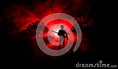 Man with riffle at spooky forest at night. Strange silhouette of hunter in a dark spooky forest at night, mystical landscape surre Stock Photo