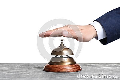 Man ringing hotel service bell at stone table Stock Photo