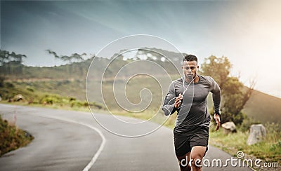 Man, road running and space in nature for exercise mockup, wellness or music with commitment for health. African male Stock Photo