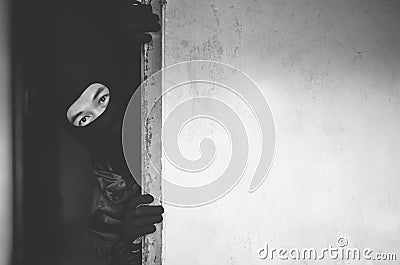 Man robber,Thief in mask hiding behind a empty wall with space for text Stock Photo