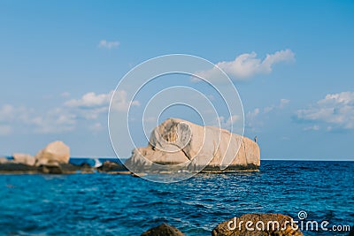 The man on the rock is going to jump into the sea. A rock in the blue sea and a cloud in the sky. Koh Tao beach in Thailand Stock Photo