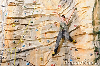 Man on rock wall in sport center Stock Photo