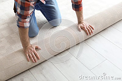 Man rolling out new carpet flooring Stock Photo