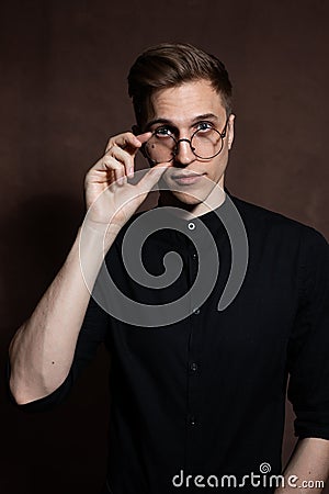 Man in round glasses and a black shirt Stock Photo