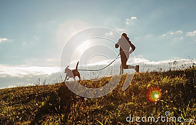 Man runing with his beagle dog at sunny morning. Healthy lifestyle and Canicross exercises jogging concept image Stock Photo