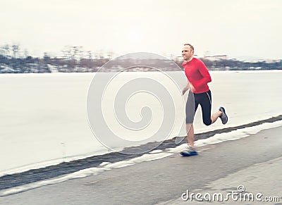 Man runing near winter lake Stock Photo