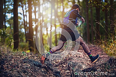 A man Runner of Trail . and athlete`s feet wearing sports shoes for trail running in the forest Stock Photo