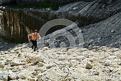 Man Running Up Rocky Hill, Exercising During Outdoor Workout. Sp Stock Photo