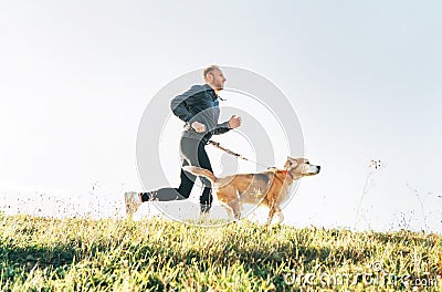 Man runs with his beagle dog. Morning Canicross exercise concept image Stock Photo