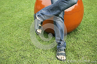 Man`s feet in black sandals on grass Stock Photo