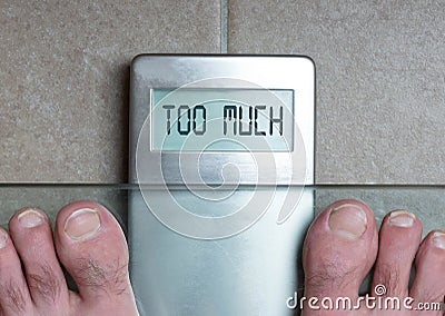 Man`s feet on weight scale - Too much Stock Photo