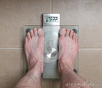 Man`s feet on weight scale - WTF!!! Stock Photo