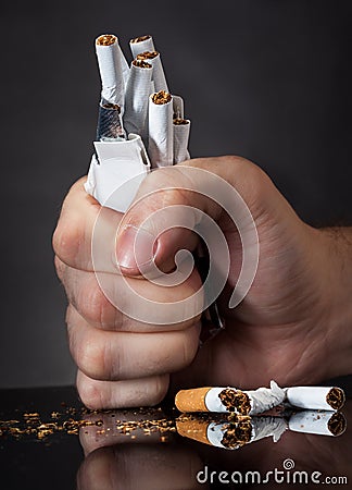 Man's Fist Crushing Cigarettes Stock Photo