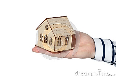 A man's hand in a classic shirt holds a small wooden house Stock Photo