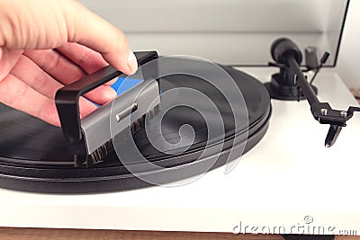 Man`s hand cleaning vinyl with special brush - turntable vinyl record player, vintage record player. Trends in music concept. Stock Photo