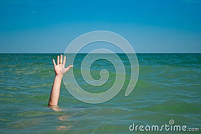 A man`s hand drowns in water calling for help, against the background of the sea and sky clouds summer Stock Photo