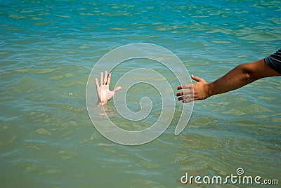 A man`s hand drowns in water calling for help, man helps rescue, against the background of the sea Stock Photo