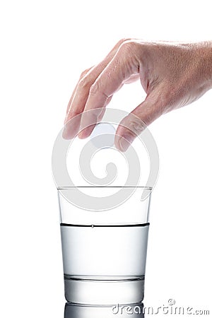 Man`s hand holding an aspirin pill dropping it in a water of glass isolated on white background with clipping path included Stock Photo