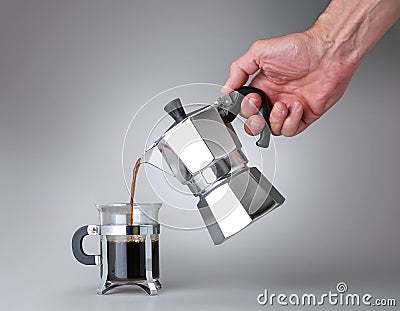 Hand holding and pouring italian coffee into a Glass cup Stock Photo