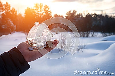 man's hand holding small glass, crystal house and keys in the palm of his hand Stock Photo