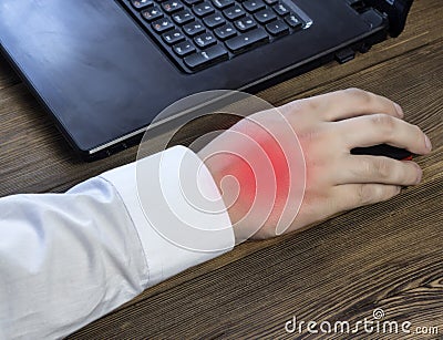 A man`s hand holds a mouse while working at a computer, a pain in his hand, a close-up Stock Photo