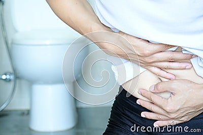 Man`s hand, he holds a roll of toilet paper Going to the bathroom Toilet toilet background Stock Photo