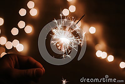 Man`s hand holds sparklers, Happy New Year Stock Photo