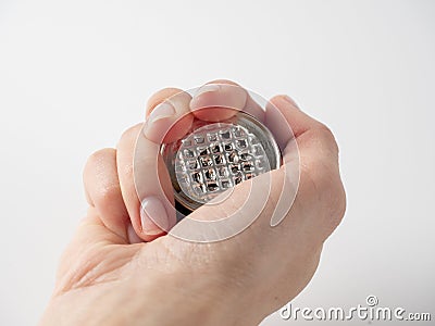 A man`s hand holds a used aluminum coffee capsule on a white background. Modern ways of storing coffee Stock Photo