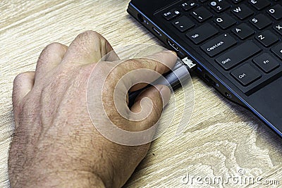 A man`s hand inserting a flash card into the laptop connector Stock Photo