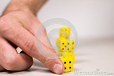 Man`s Hand Lining up Holding Yellow Dice Stock Photo