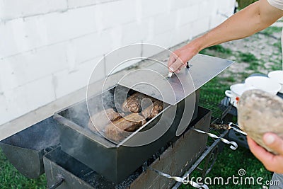 A man`s hand opens a smokebox with lard in nature. Country dinner Stock Photo