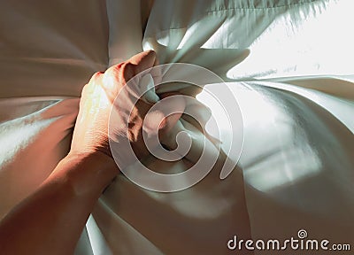 The man`s hand pulled the white sheets, Hand mauled the white sheets on the bed, hands of a doctor with patient in the hospital Stock Photo