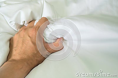 The man`s hand pulled the white sheets, Hand mauled the white sheets on the bed, hands of a doctor with patient in the hospital. Stock Photo