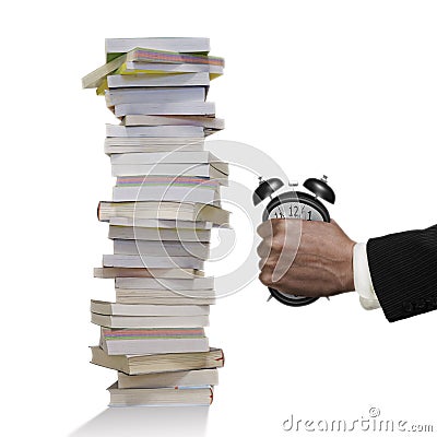 Man`s hand seizing alarm clock to deformation with stack books Stock Photo