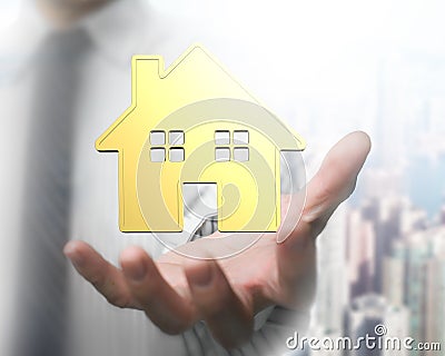 Man`s hand showing golden house Stock Photo