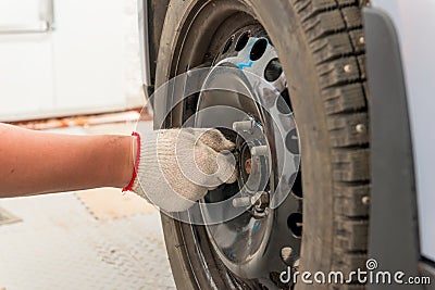 Man's hand tightening the screws on the wheel Stock Photo