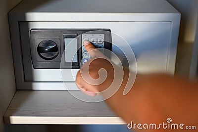 Man's hand types in the combination of a small safe Stock Photo