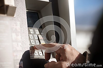 Man`s hand types secret number into a cash machine Stock Photo